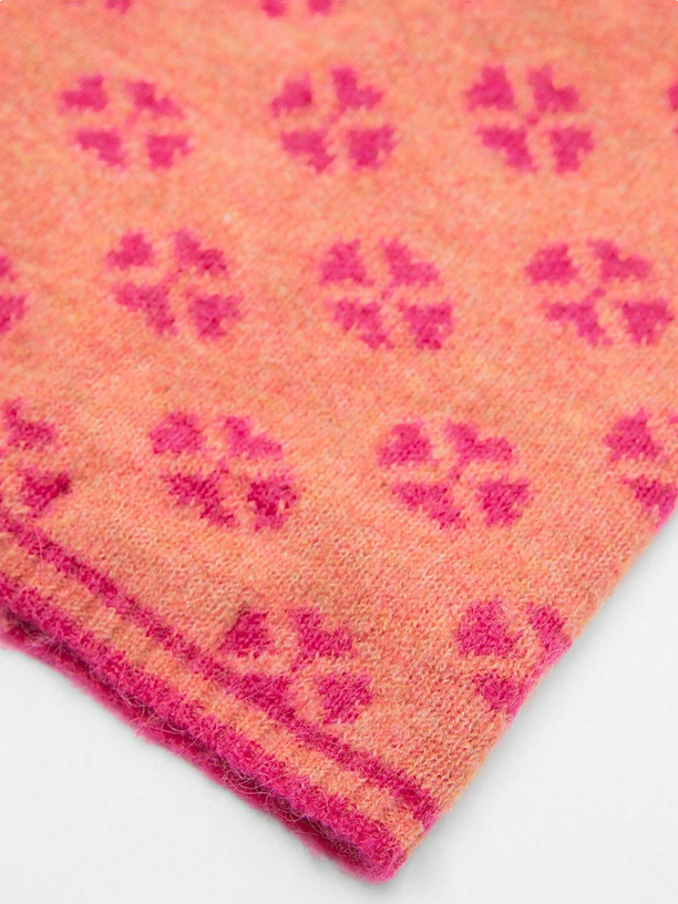 Close-up of a pink fabric with a floral pattern on a white background