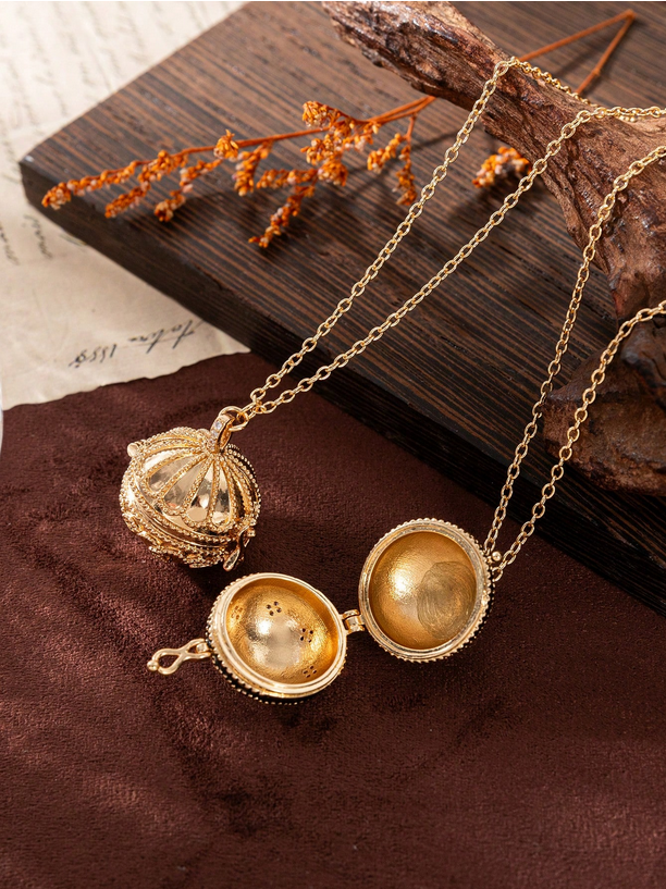 Gold necklace with a decorative pendant on a wooden surface