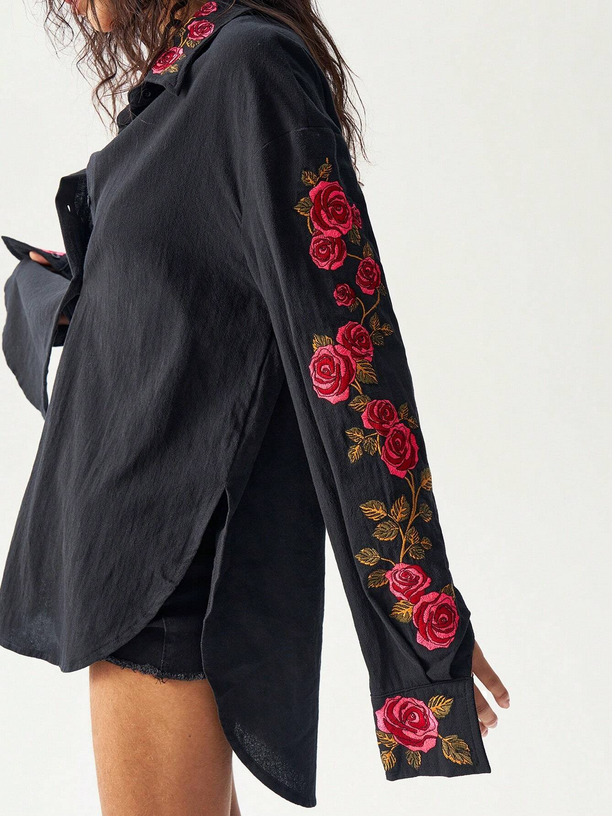 Black shirt with red floral embroidery on sleeves against a white background