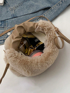 Beige furry handbag with denim jacket on a white surface