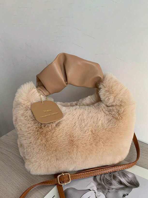 Beige fur handbag with brown leather accents on a light gray surface.