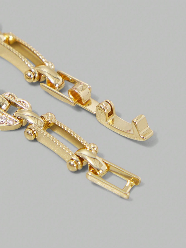 Close-up of a gold bracelet on a gray background