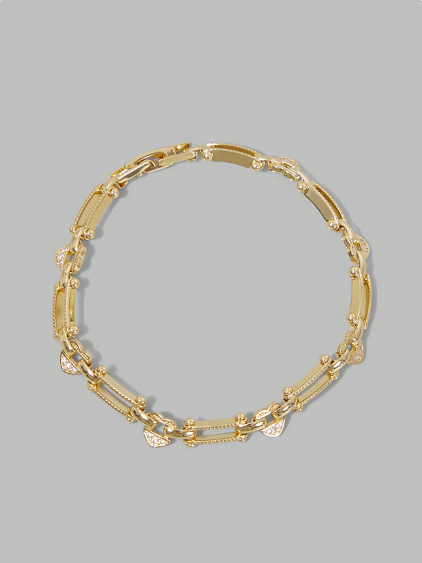 Gold chain bracelet on a gray background