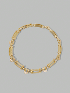 Gold chain bracelet on a gray background