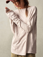 Person wearing a light gray long-sleeve shirt against a plain background