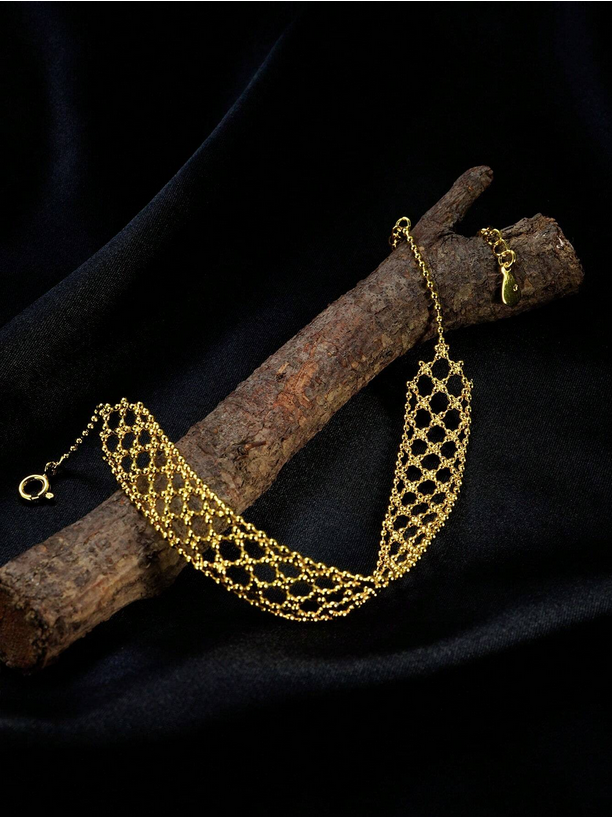 Gold chain necklace on a dark background