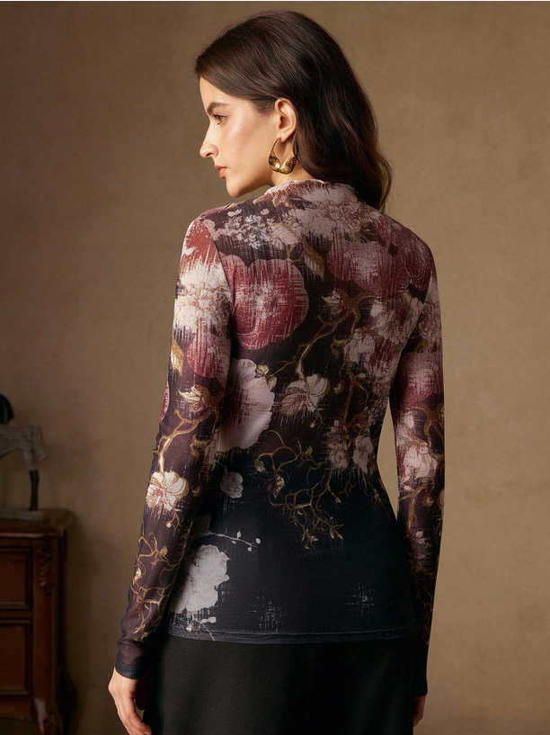 Woman wearing a long-sleeve top with floral pattern against a beige wall