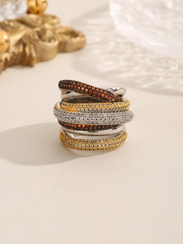 Stack of gold, silver, and bronze rings on a light background