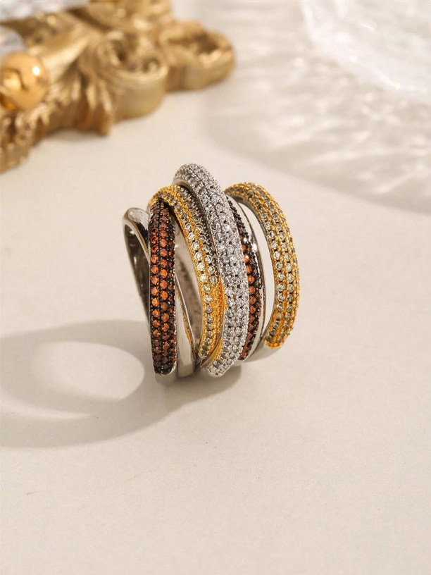 Set of four multi-colored rings on a beige surface