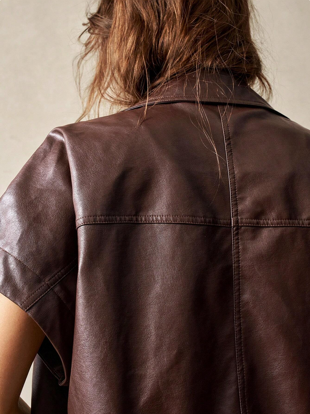 Brown leather shirt worn by a person with a neutral background