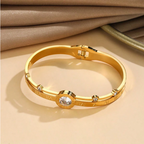 Gold bracelet with gemstones on a beige background