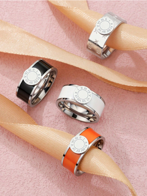 Three rings with different colored bands on a pink background