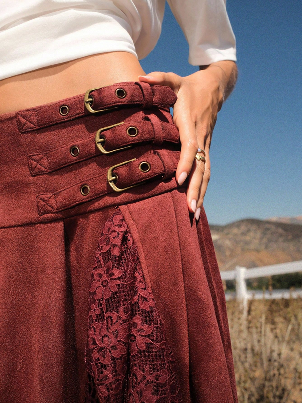 Close-up of a person wearing a burgundy skirt with gold buckles against a scenic background.