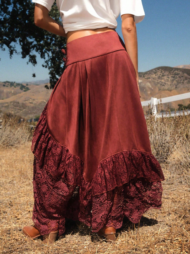 Person wearing a long burgundy skirt with ruffles in an outdoor setting