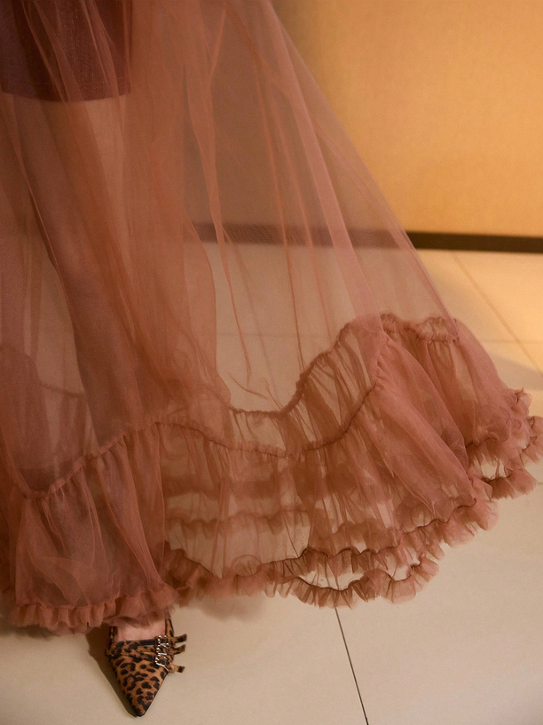 Pink sheer skirt with ruffles on a white surface