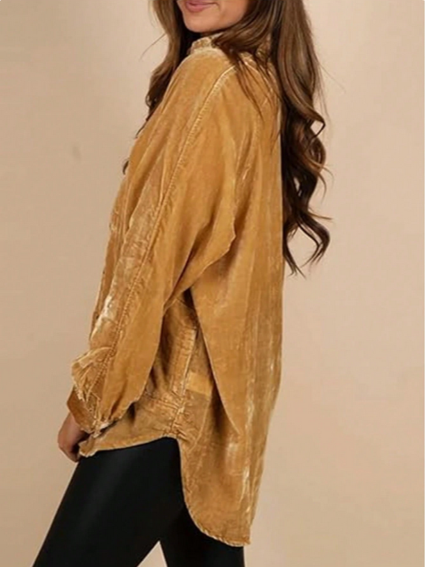 Woman wearing a mustard yellow oversized shirt against a beige background